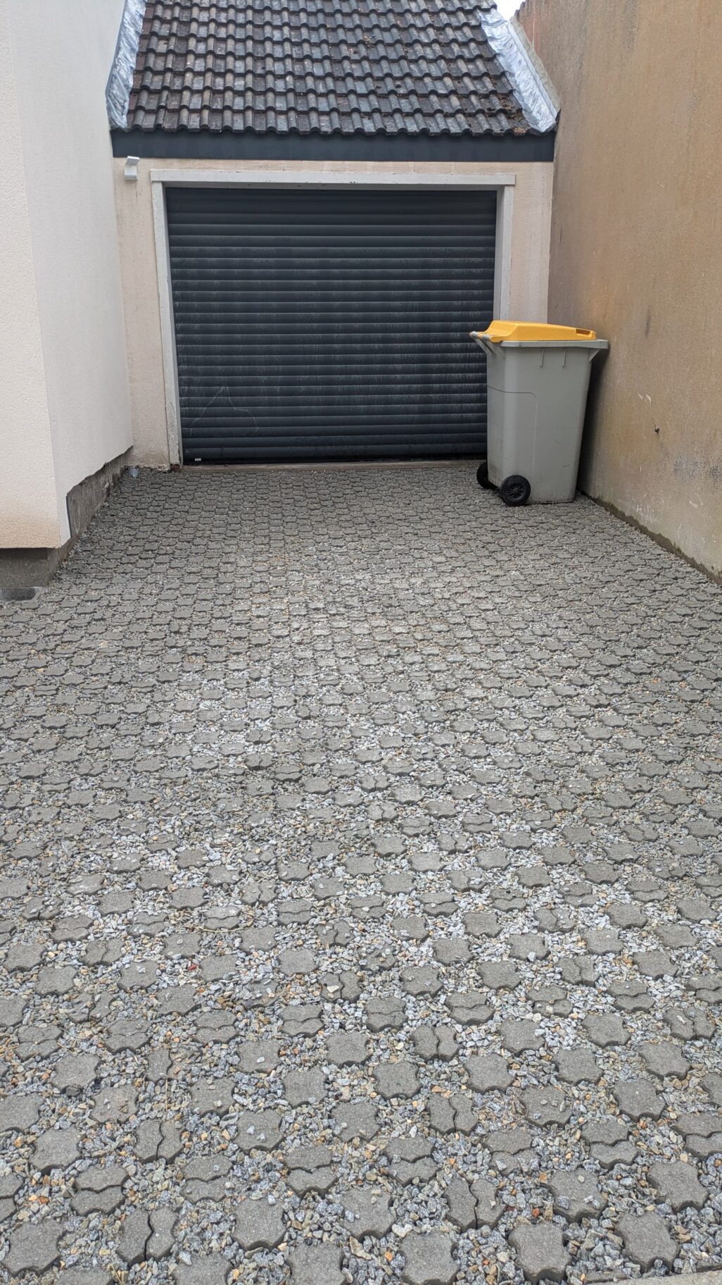 Aménagement extérieur terminé : portail aluminium gris 7016, clôture rénovée et accès garage en dalle stabilisée à Nantes.