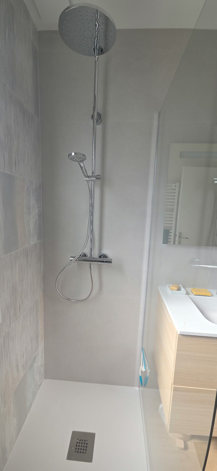 Douche extra-plate avec faïence toute hauteur dans une salle d’eau